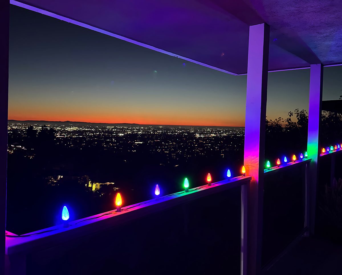 Multicolor bulbs on a hillside patio rail